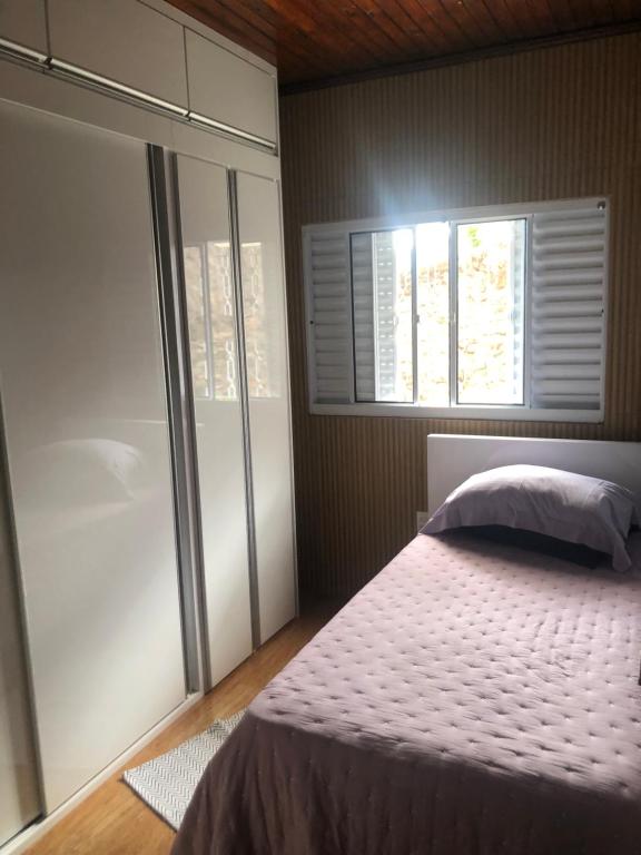 um quarto com uma cama e uma janela em Casa do Vale em Serra Negra