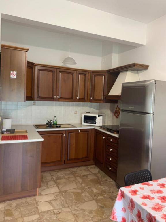 kuchnia z drewnianymi szafkami i lodówką ze stali nierdzewnej w obiekcie Nella’s home w mieście Gavi