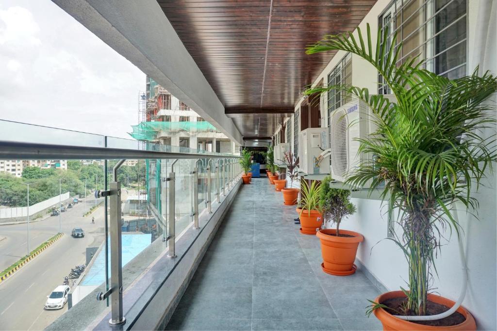 uma varanda com vasos de plantas ao lado de um edifício em OYO Collection O Hotel Rk Inn em Pune