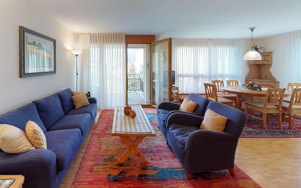 sala de estar con sofás azules y comedor en Surpunt 44 en St. Moritz