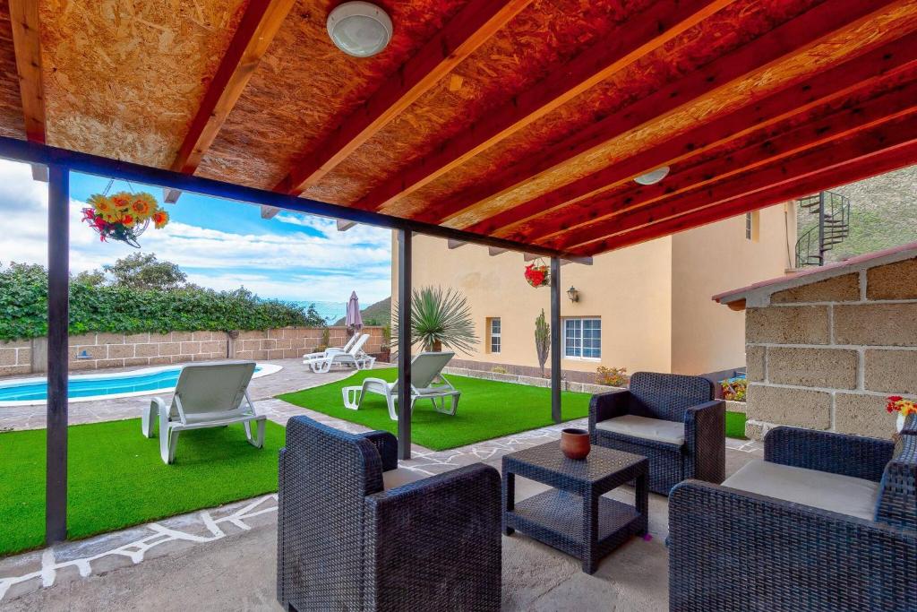 a patio with chairs and a pool in a house at Beautiful Arianny House With Pool in Arona