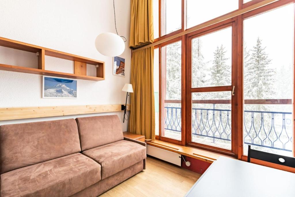 un salon avec un canapé et une grande fenêtre dans l'établissement Résidences quartier Charmettoger - maeva Home - Studio 6 personnes - Confort MAE-0821, à Arc 1800