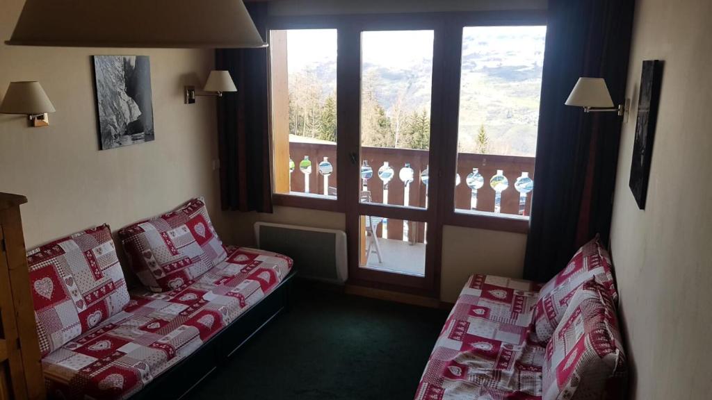 une chambre d'hôtel avec un canapé et une fenêtre dans l'établissement Résidence La Marelle et Le Rami - maeva Home - 2 Pièces 5 Personnes Sélection MAE-1197, à La Plagne Tarentaise