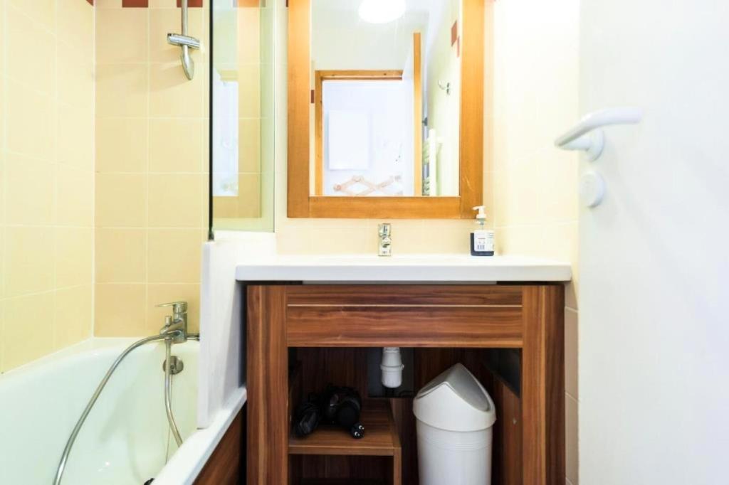 a bathroom with a sink and a tub and a mirror at Résidence Les Temples du Soleil - maeva Home - 2 Pièces 5 Personnes Sélect 52 in Val Thorens