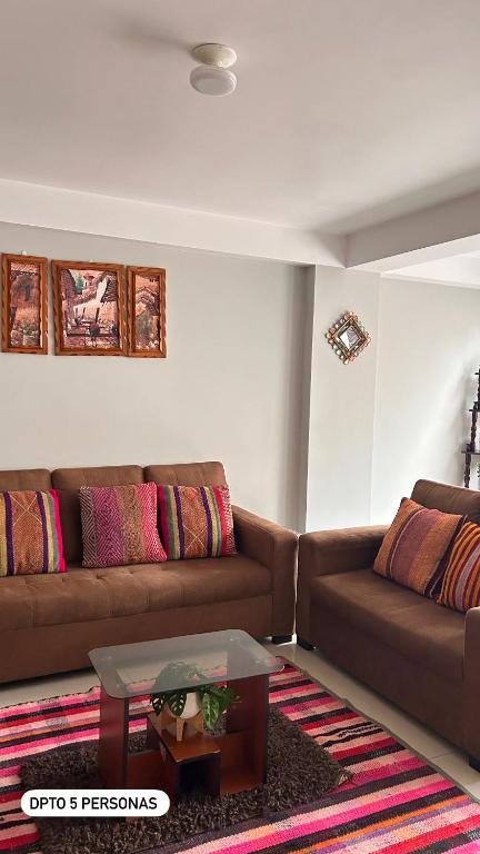 a living room with two brown couches and a table at El Viejo Roble in Cusco