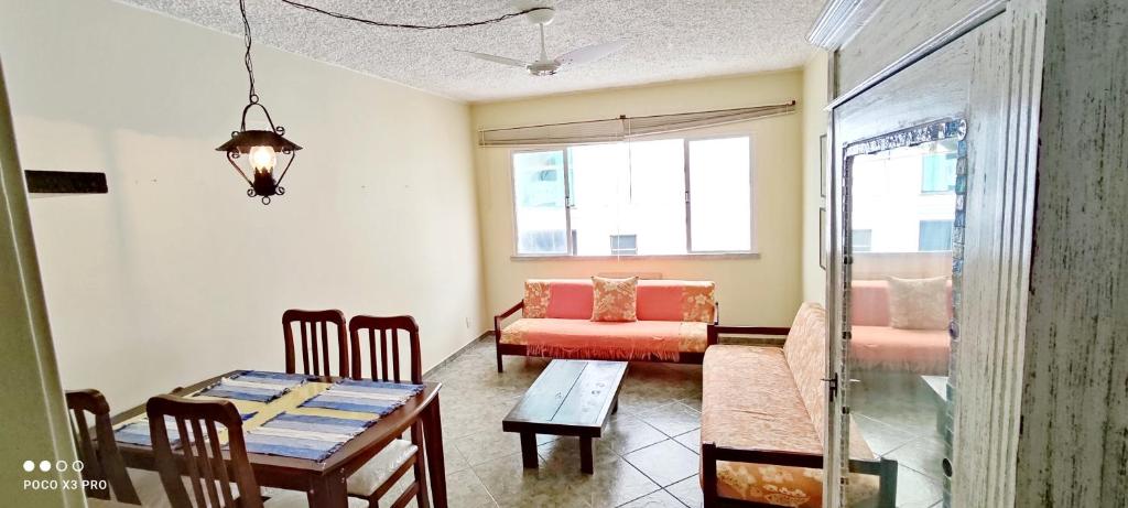 a living room with a table and a couch at Ap a 50m da Prainha em Arraial in Arraial do Cabo