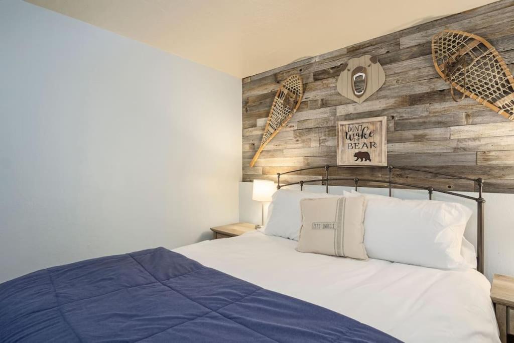 a bedroom with a bed and a wooden wall at Grumpy Grizzly in Sandy