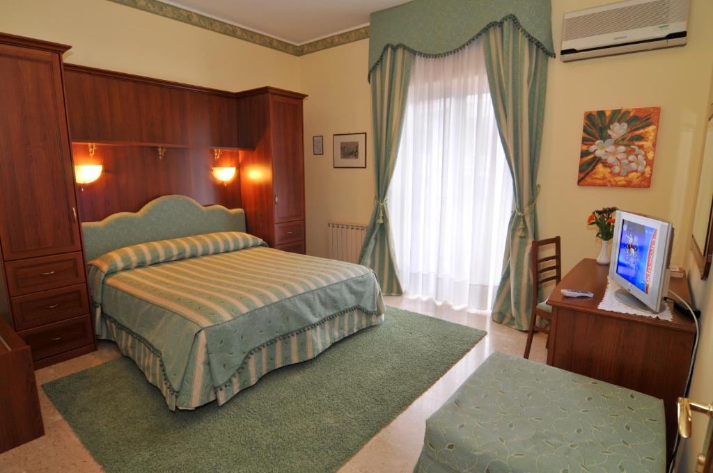 sypialnia z łóżkiem i telewizorem w obiekcie Hotel Ristorante Thomas w mieście Torregrotta