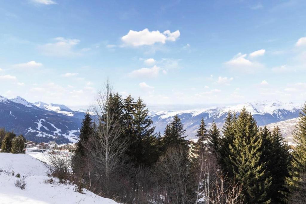 une montagne enneigée avec des arbres et des montagnes en arrière-plan dans l'établissement Résidence Le Roselend - maeva Home - Appartement 4 Pièces 8 Personnes - Sélection MAE-1642, à Bourg-Saint-Maurice