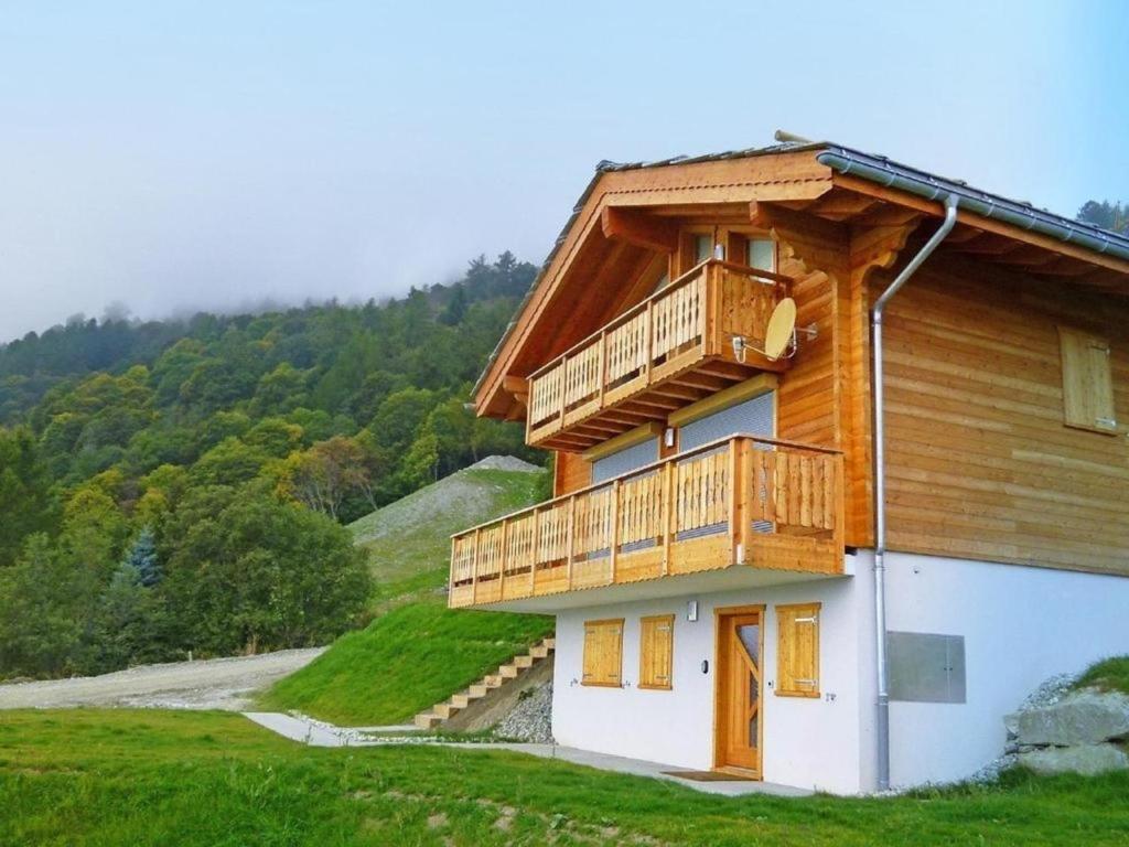 une maison en bois avec un balcon sur une colline dans l'établissement Chalet Falcons Nest, à Hérémence