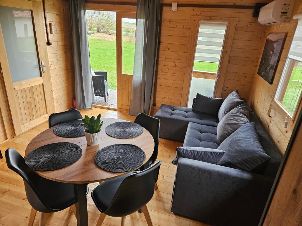 ein Wohnzimmer mit einem Tisch und einem Sofa in der Unterkunft Domki Letniskowe przy Strażnicy in Radków