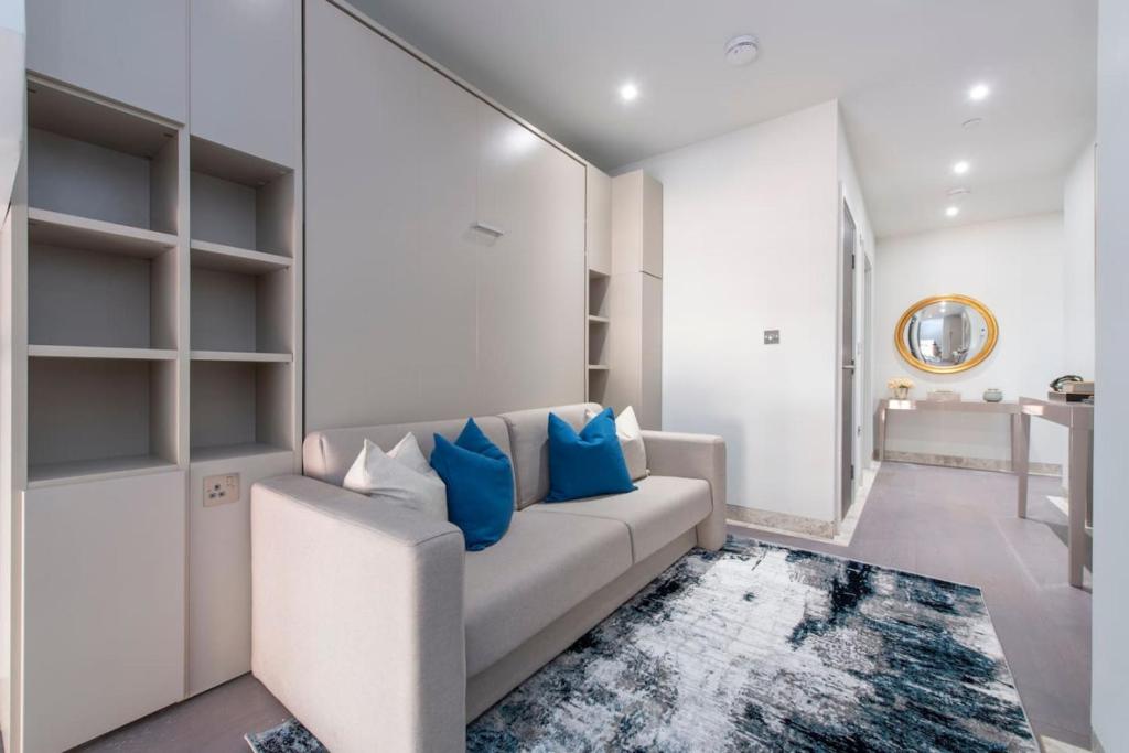 een woonkamer met een witte bank en blauwe kussens bij Exquisite Studio - Heart of Reading Centre in Reading