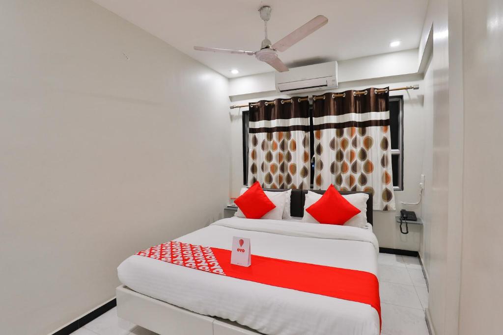 1 Schlafzimmer mit 2 Betten und roten Kissen in der Unterkunft OYO Nova Hotel Nildeep in Rajkot
