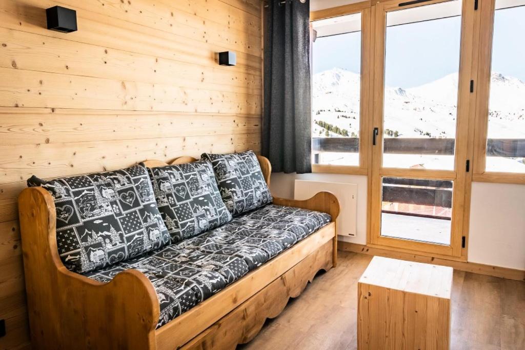 - un canapé dans une chambre avec fenêtre dans l'établissement Résidence Les Constellations - maeva Home - Studio 4 Personnes - Confort MAE-4098, à La Plagne Tarentaise