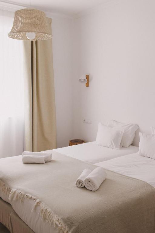 two beds in a room with towels on them at Pure Fonte Velha B&B in Vila do Bispo