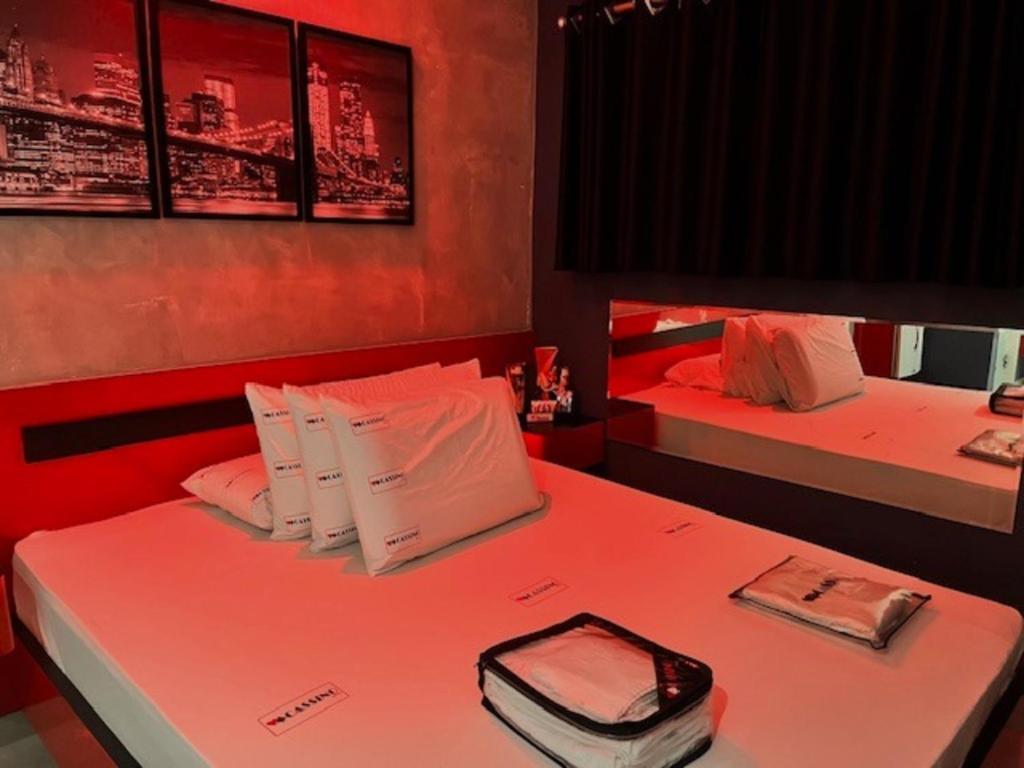 Habitación con 2 camas con iluminación roja en Cassino Motel 4 en Santo André