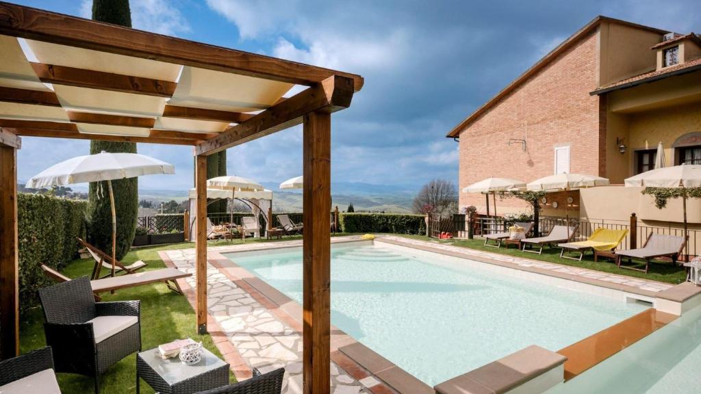 una piscina con sillas y sombrilla en La Sassolina, en Montaione