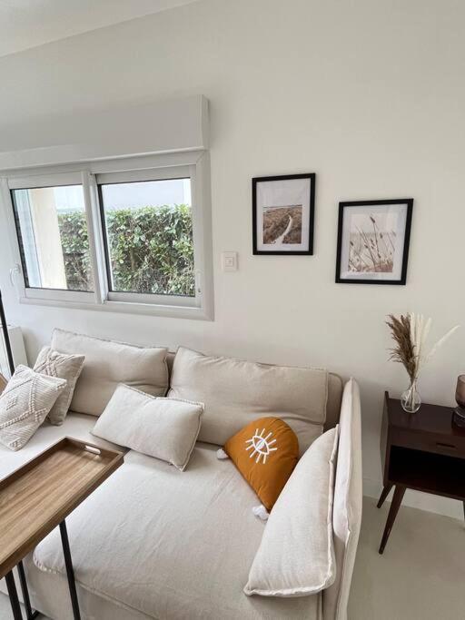 un salon avec un canapé et une table dans l'établissement Maison vue sur la nature proche golf & Carnac, à Ploemel