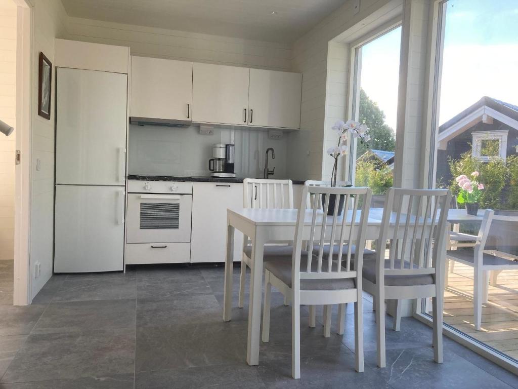 eine Küche mit einem weißen Tisch und Stühlen sowie einem Tisch und einem Tisch in der Unterkunft Ferienhaus für 8 Personen ca 50 m in Rockneby, Südschweden Schärengarten der Südostküste in Rockneby