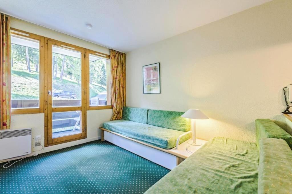 Cette petite chambre comprend un canapé et une fenêtre. dans l'établissement Résidence Le Hameau du Sauget - maeva Home - 2 Pièces 4 Personnes Confort MAE-6712, à La Plagne Tarentaise