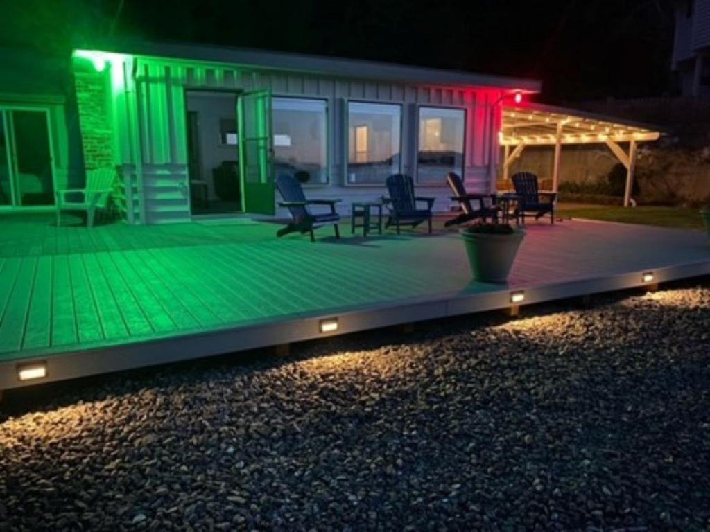 una casa con una terraza verde por la noche en 116 - Inviting Waterfront Haven BBQ, en Gig Harbor