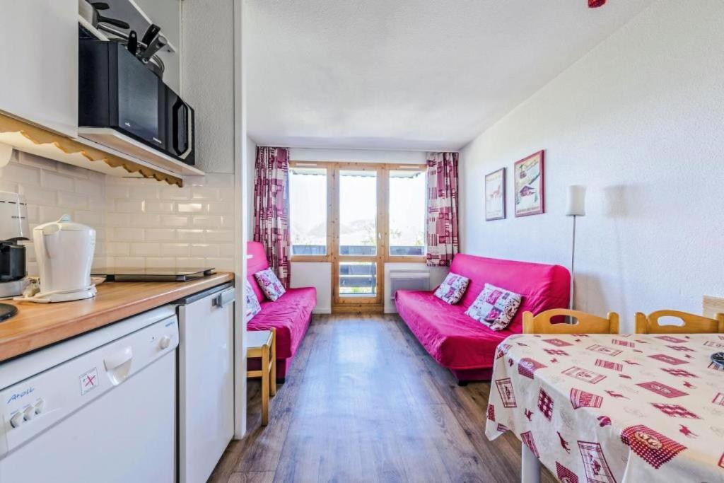 Il dispose d'une cuisine et d'un salon avec un canapé et une table. dans l'établissement Résidence Le Sextant - maeva Home - Studio 4 Personnes Sélection MAE-6066, à La Plagne Tarentaise