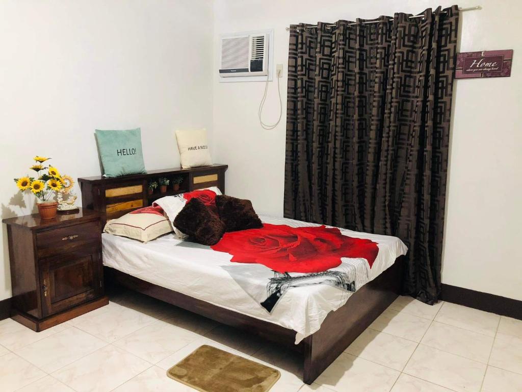 a bedroom with a bed with a red dress on it at 15pax-U1-Rose&Fer Vigan Transient-Near Calle Crisologo in Bantay