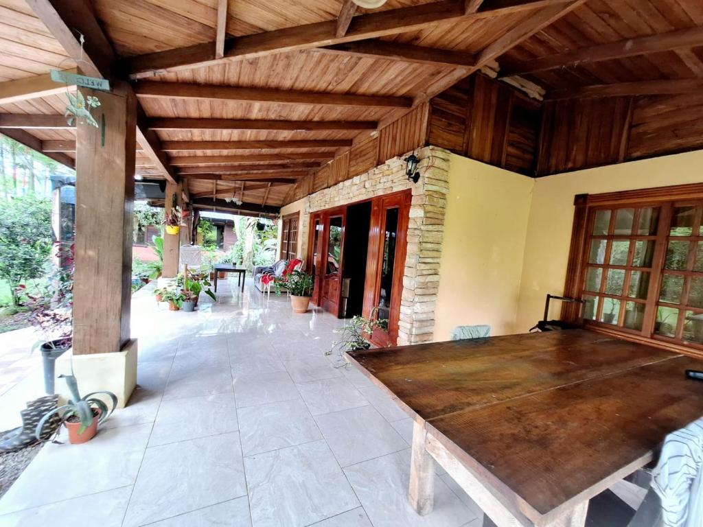 un patio con tavolo in legno in una casa di VILLA ESMERALDA a Siquirres