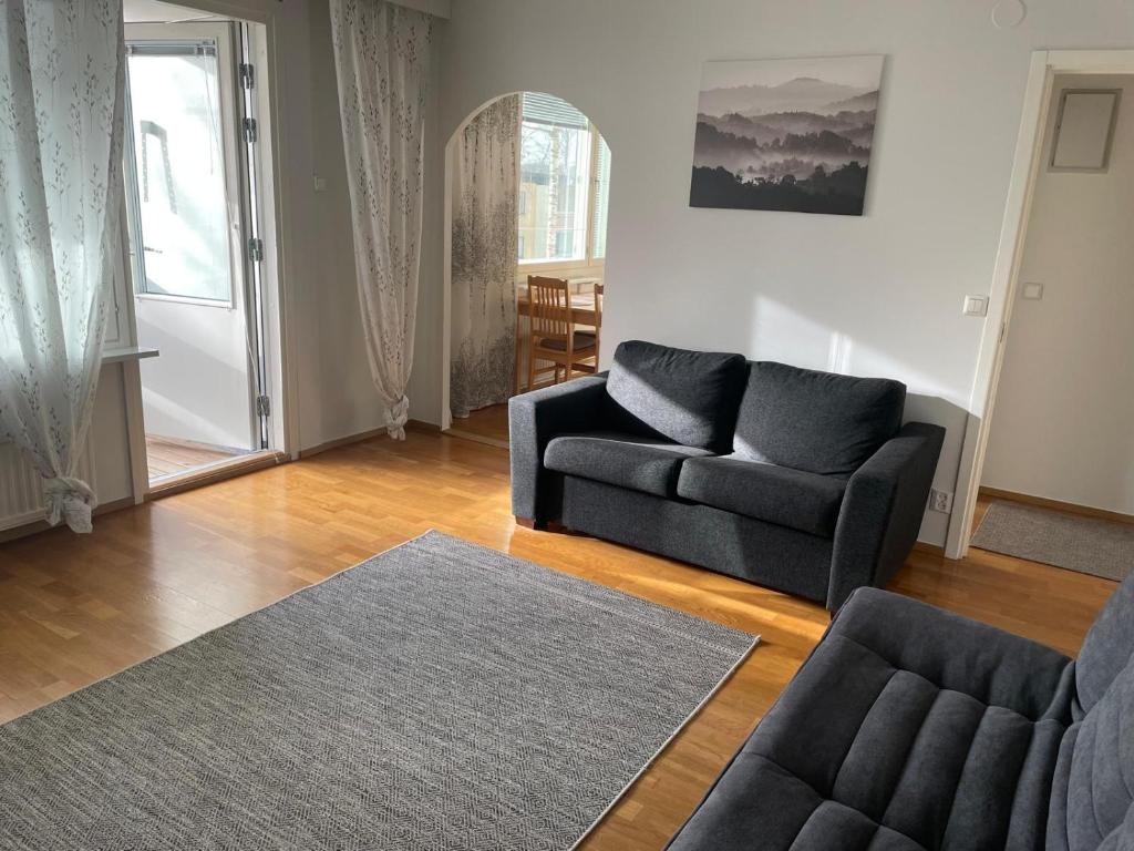 sala de estar con sofá y silla en Helsinki Area Apartment 15 Min to Airport With Own Parking Lot, en Vantaa