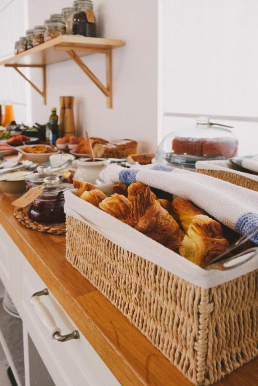 a table with baskets of bread and other foods at Pure Fonte Velha B&B in Vila do Bispo