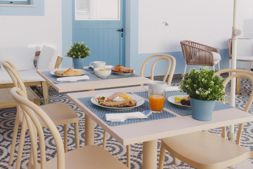 a table with plates of food and orange juice at Pure Fonte Velha B&B in Vila do Bispo
