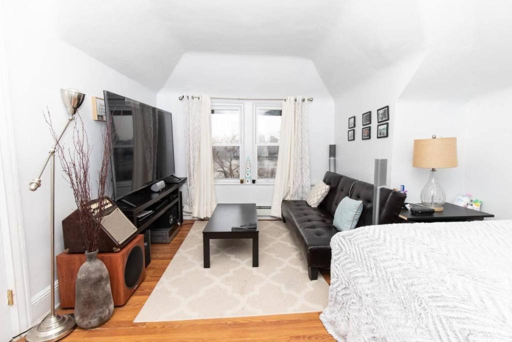 ein Wohnzimmer mit einem Bett und einem Sofa in der Unterkunft Skyline 3 BR 20mins to T-Square #3 in West New York