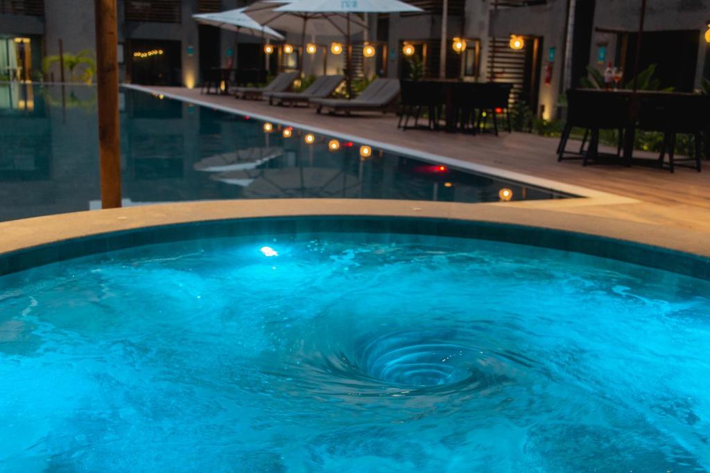- une grande piscine d'eau bleue la nuit dans l'établissement Flat Villas Manatee Rota Ecológica dos Milagres, à Porto de Pedras