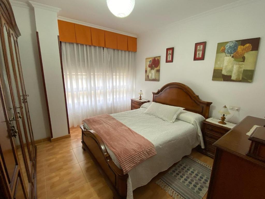 um quarto com uma cama grande e uma janela em Vivienda de Uso turístico Paseo del Suaron Vegadeo em Vegadeo