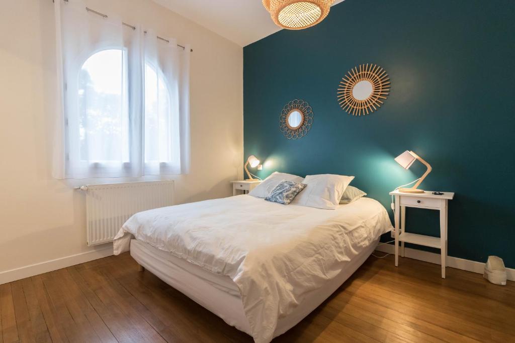 ein Schlafzimmer mit einem großen Bett und einer blauen Wand in der Unterkunft Chambres D'hôte Le Cèdre Bleu in Saint-Jean