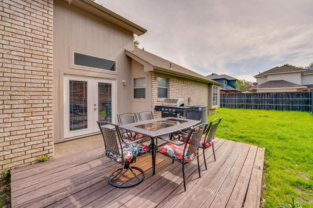 un patio con mesa y sillas en una terraza de madera en Updated Coppell Home with Fenced Yard and Gas Grill! en Coppell