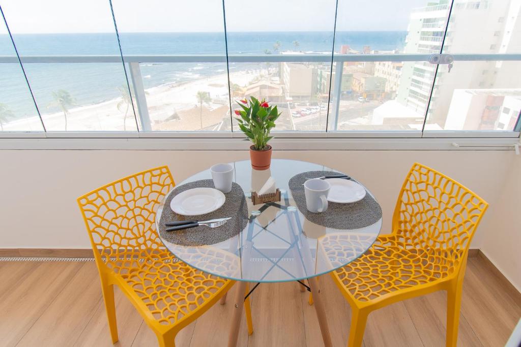 een eetkamer met een glazen tafel en 2 stoelen bij Beira Mar - Pituba in Salvador