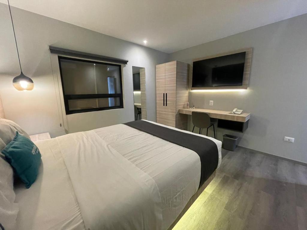 a bedroom with a bed and a desk and a television at Ayenda El Patio CDMX in Mexico City