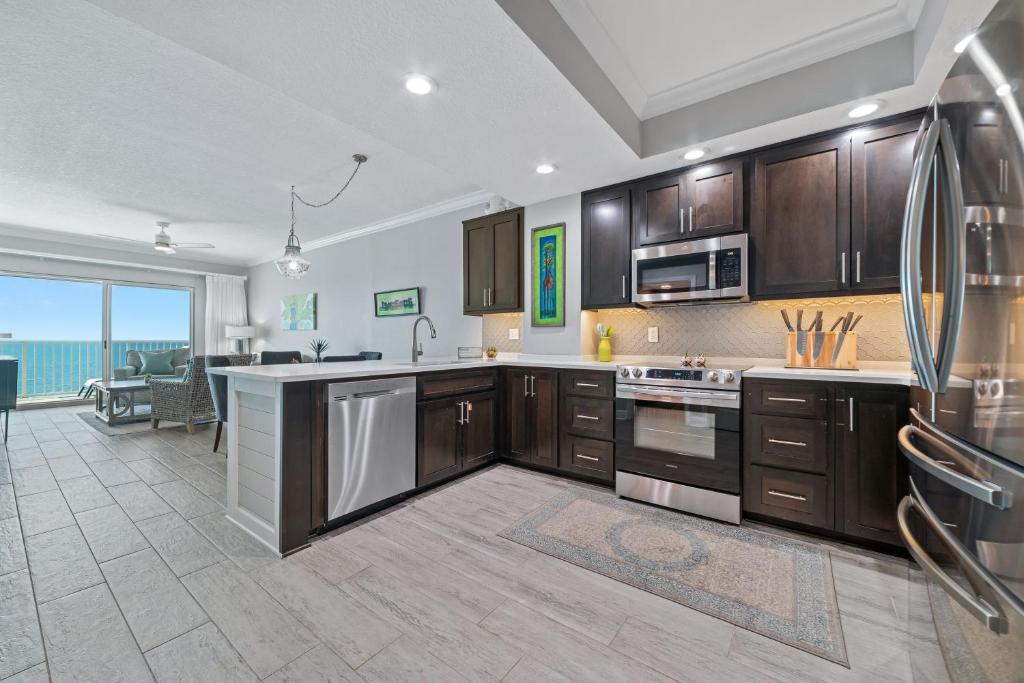 a kitchen with wooden cabinets and a large window at Crystal Shores Unit 1405 in Gulf Shores