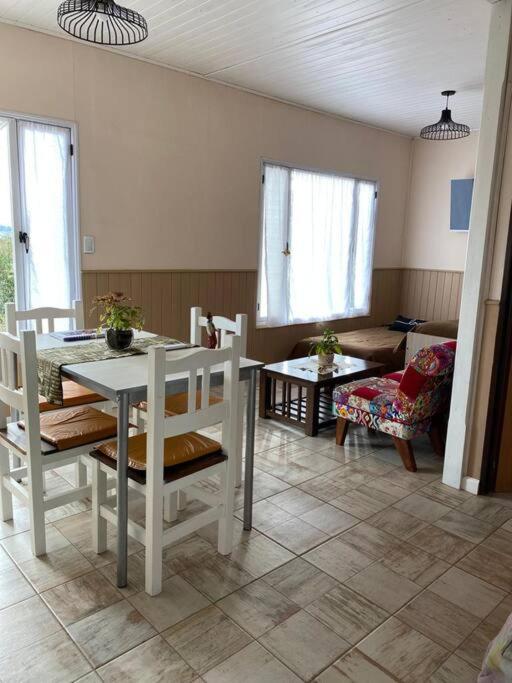 sala de estar con mesa blanca y sillas en Chez Gla - Alojamiento Bariloche en San Carlos de Bariloche