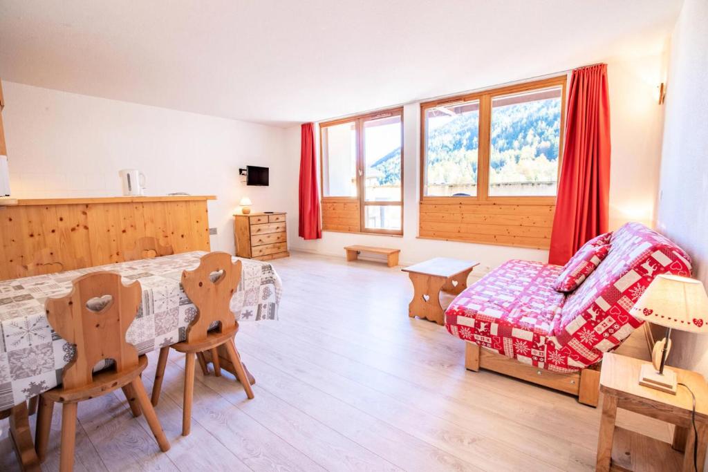 een slaapkamer met een bed en een tafel en stoelen bij Le Chalet Le Grand Air - Studio pour 4 Personnes 193060 in Villarodin-Bourget