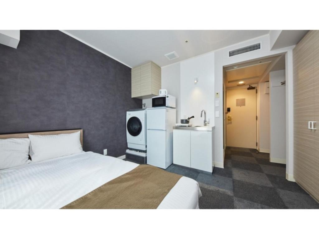 厚木市にあるRembrandt Hotel Atsugi - Vacation STAY 41675vのベッドとキッチン付きのホテルルーム