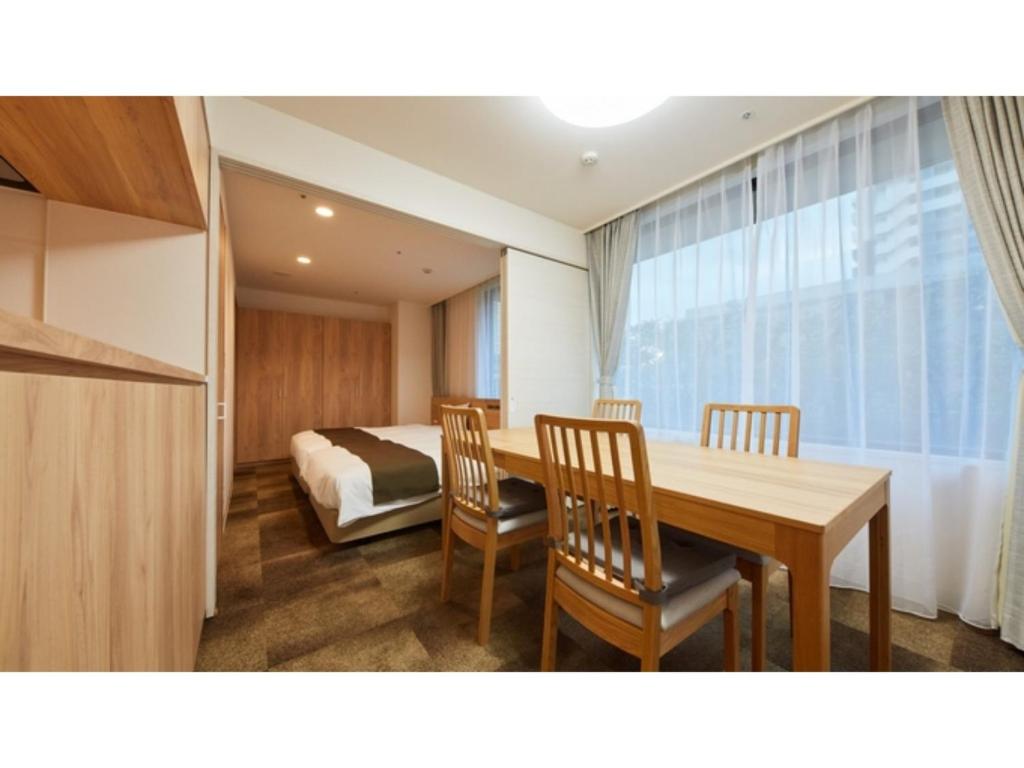 een kamer met een tafel en stoelen en een bed bij Rembrandt Hotel Atsugi - Vacation STAY 41678v in Atsugi