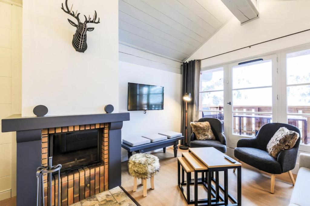 un salon avec une cheminée et une télévision dans l'établissement Résidence Les Arcs 1950 Le Village - maeva Home - Appartement 3 pièces 6 personnes - Prestige - super Home MAE-3896, à Bourg-Saint-Maurice