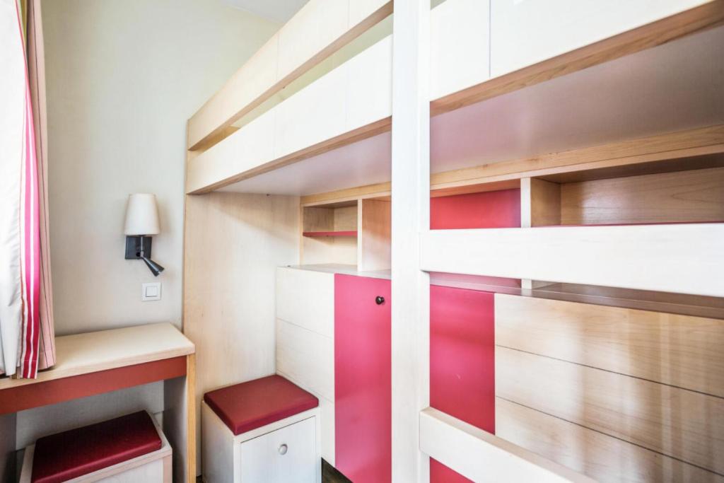 a bedroom with a bunk bed with red accents at Résidence le Village de Cap Esterel - maeva Home - Appartement 3 pièces 6 p 66 in Saint-Raphaël