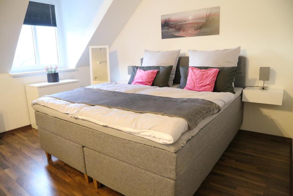 - un grand lit avec des oreillers roses dans une chambre dans l'établissement Vaubanstudio historischer Soutyhof, à Sarrelouis