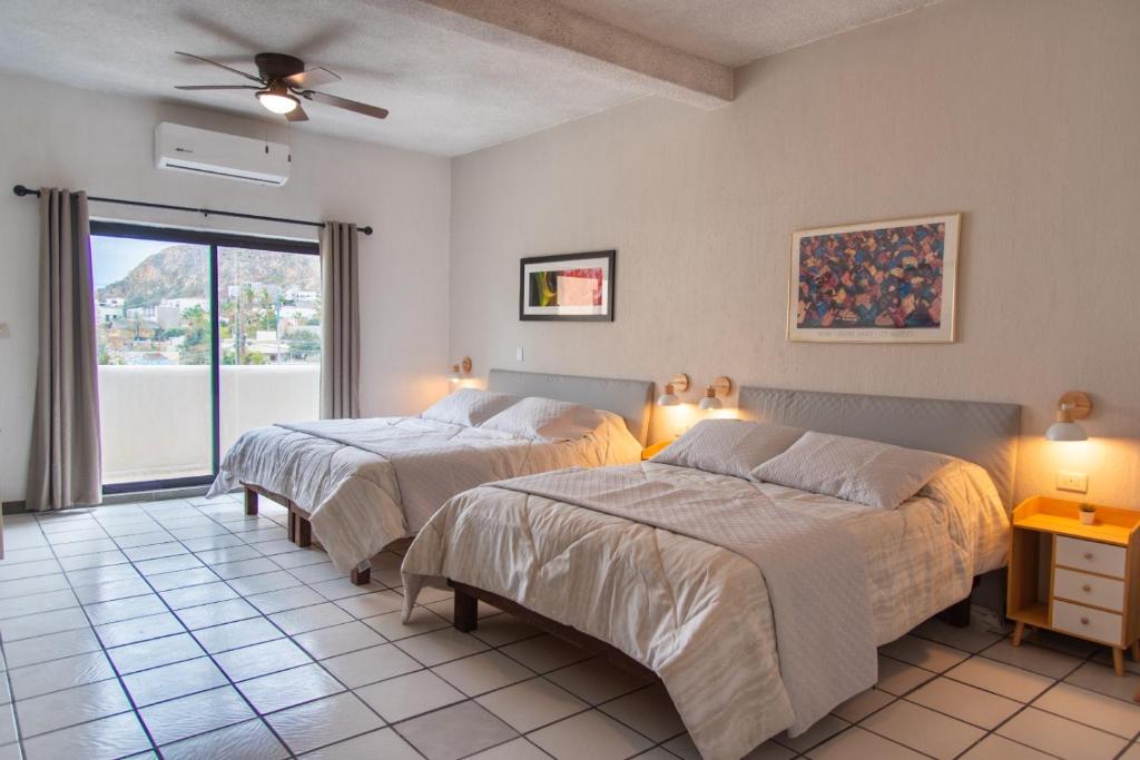 2 camas en una habitación con ventana en Casa Dei Girasoli, en Cabo San Lucas