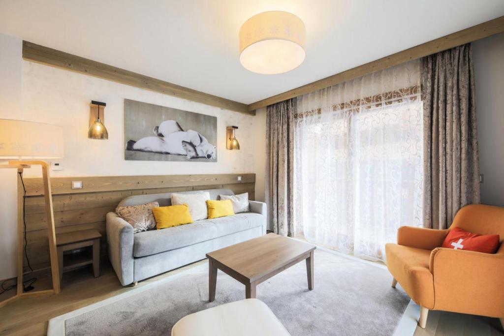 ein Wohnzimmer mit einem Sofa und einem Tisch in der Unterkunft Résidence Premium L'Hévana - maeva Home - Appartement 3 pièces 7 personnes 55 in Les Allues