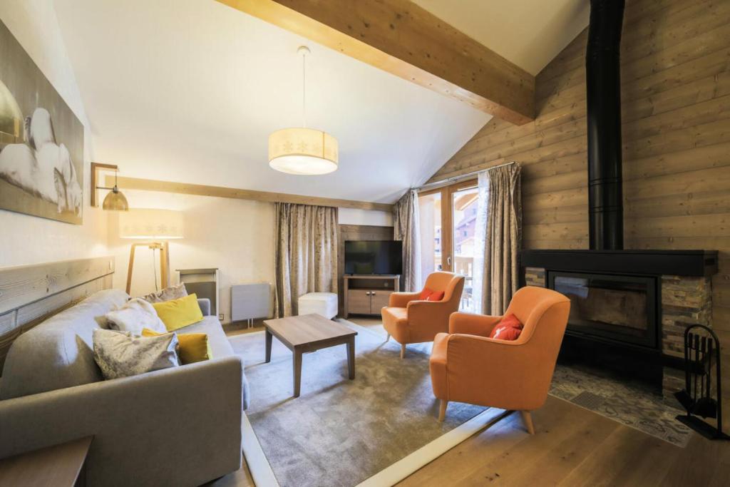 a living room with a couch and chairs and a fireplace at Résidence Premium L'Hévana - maeva Home - Appartement 4 pièces 8 personnes Prestige MAE-6261 in Les Allues