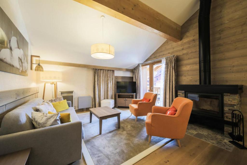 a living room with a couch and chairs and a fireplace at Résidence Premium L'Hévana - maeva Home - Appartement 4 pièces 8 personnes 61 in Les Allues
